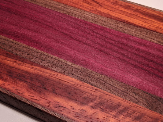 Close-up of handmade face-grain bar board showing walnut, purpleheart, and padauk wood grain and colors by Great Scott Woodworks