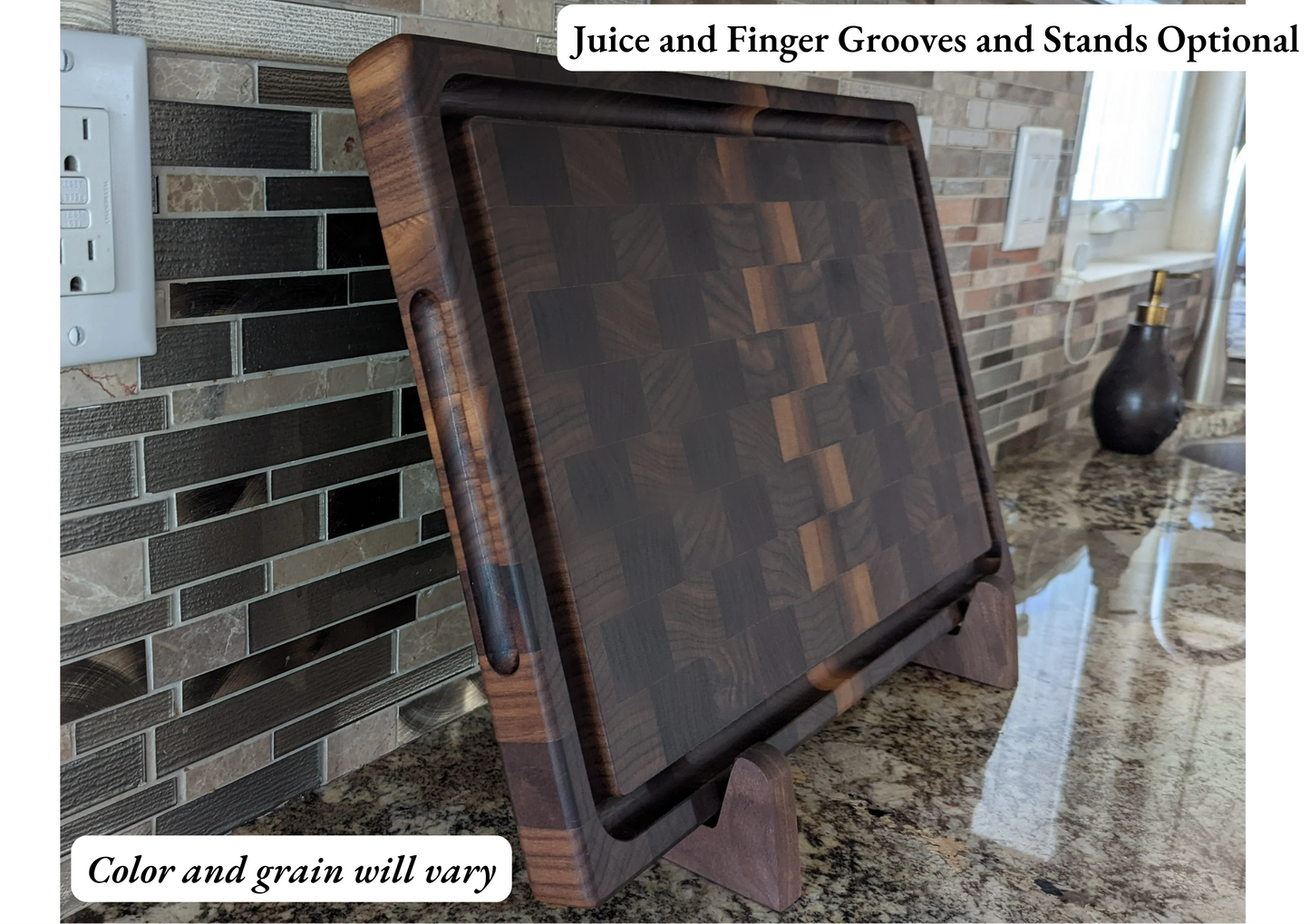 A handcrafted end‑grain cutting board with a rich hardwood block pattern, shown upright on a stand in a kitchen setting with a granite countertop and tile backsplash. The board features a juice groove and finger grooves, and the image includes the text “Juice and Finger Grooves and Stands Optional” and “Color and grain will vary.” This premium butcher‑block‑style board is designed for chefs and home cooks who want a durable, high‑quality cutting surface for chopping, meal prep, and serving.