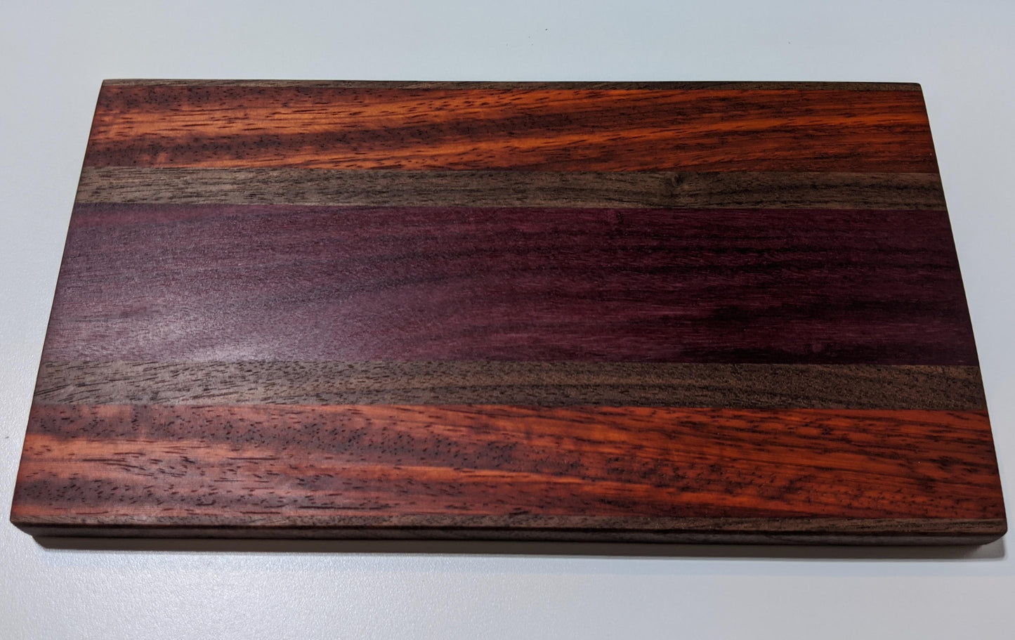 Top view of handmade walnut purpleheart and padauk face-grain bar and charcuterie board by Great Scott Woodworks